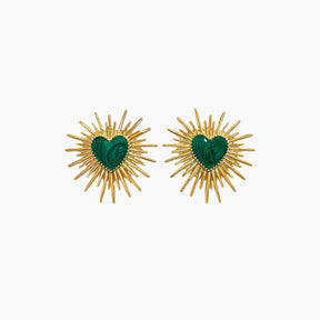 Pair of earrings with gold sunburst design and green heart center on a white background