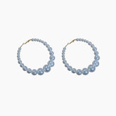 Pair of pearl hoop earrings on a white background