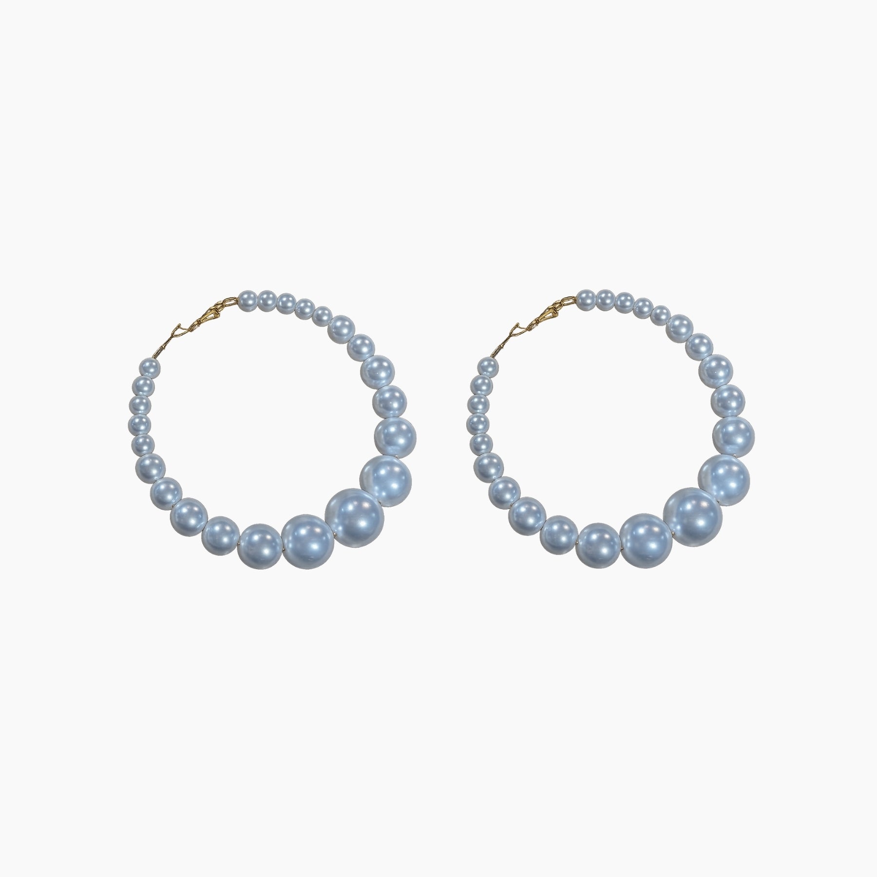 Pair of pearl hoop earrings on a white background