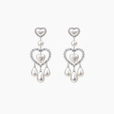 Pair of heart-shaped pearl earrings on a white background