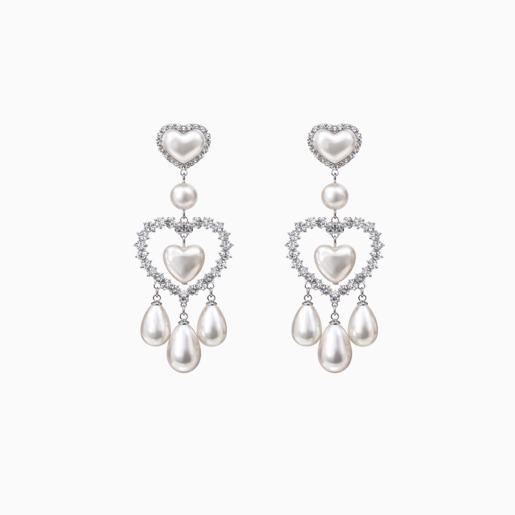 Pair of heart-shaped pearl earrings on a white background