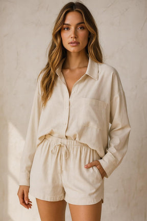Woman wearing a beige shirt and shorts set against a neutral background