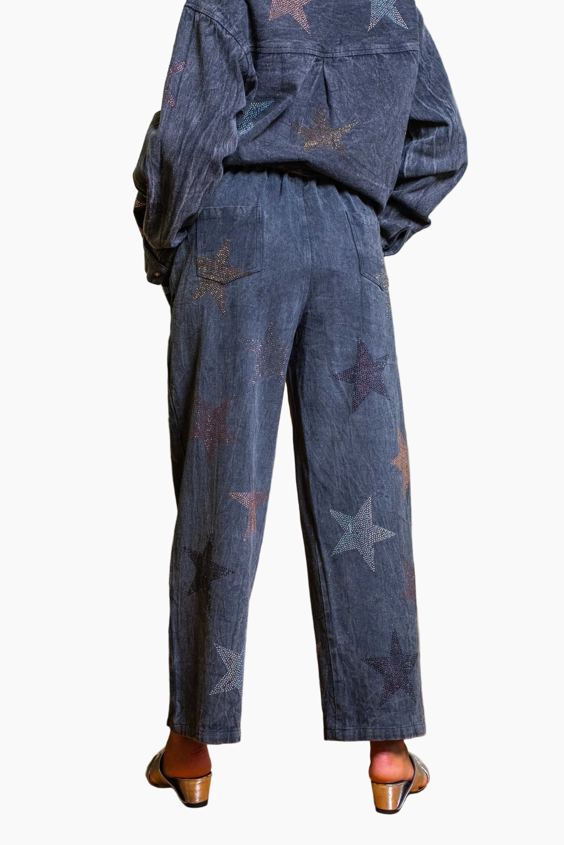 Person wearing a dark blue denim outfit with star patterns.
