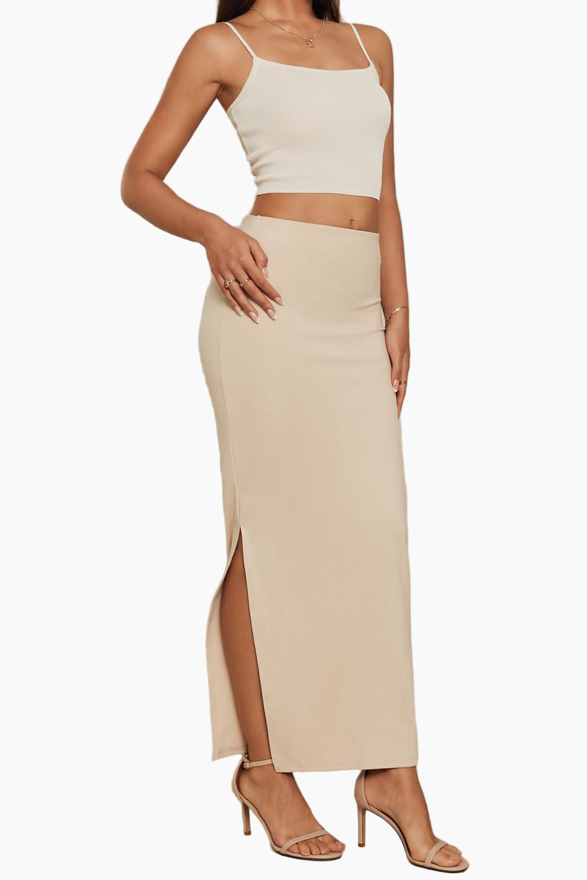 Woman wearing a beige crop top and high-waisted skirt 