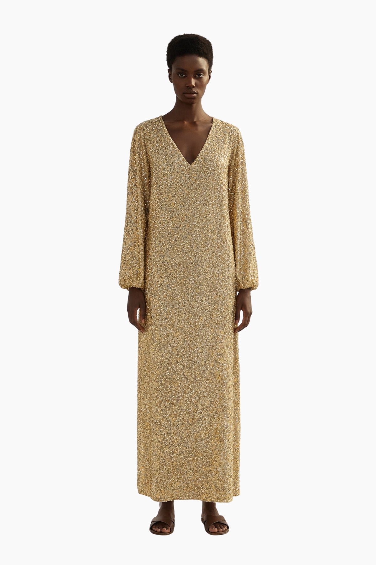 Woman wearing a long beige dress on a white background