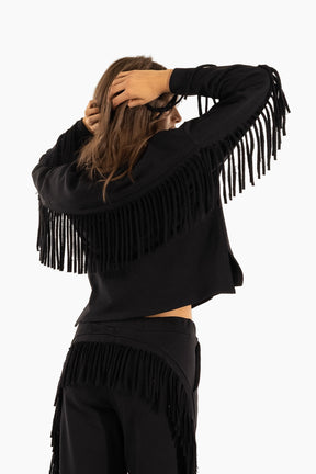 Person wearing a black fringe jacket and pants