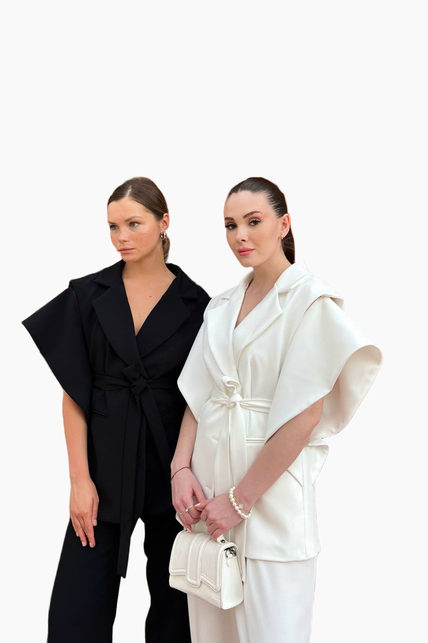 Two women wearing black and white outfits on a white background