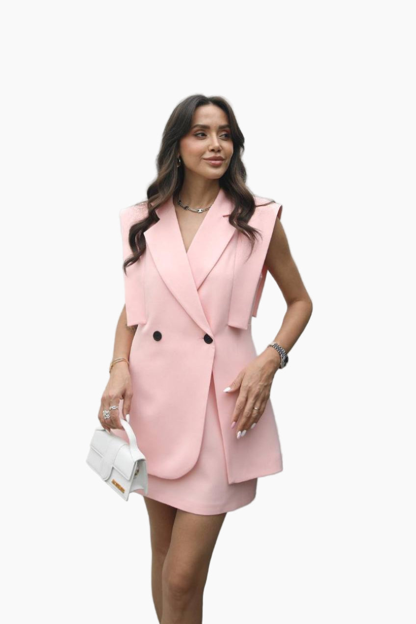 Woman wearing a pink blazer dress on a white background