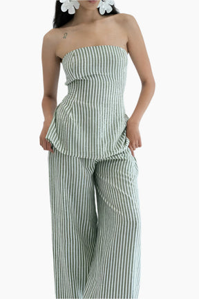 Woman wearing a green and white striped strapless top and wide-leg pants