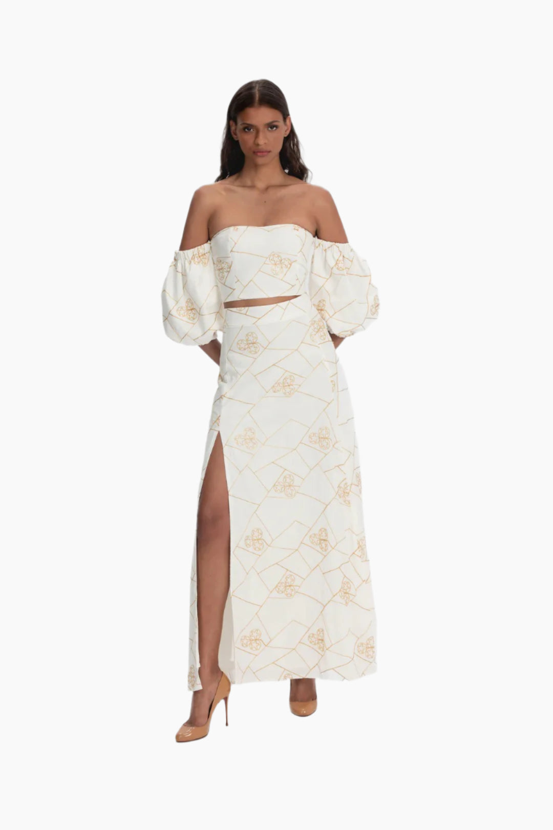 Woman wearing a white floral set, embroidered and puffed sleeve crop top and a skirt with a split 