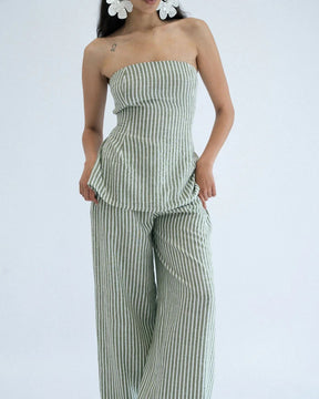 Woman wearing a green and white striped strapless top and wide-leg pants 