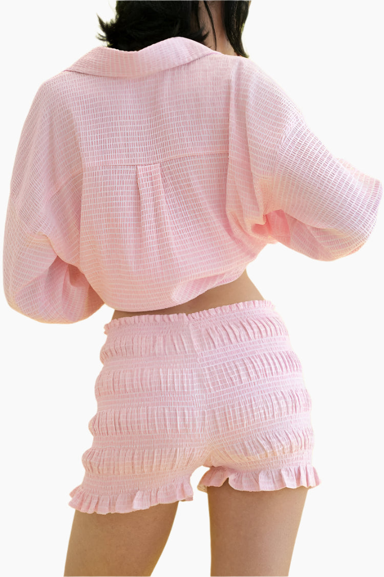Person wearing a pink textured outfit with a top and shorts 