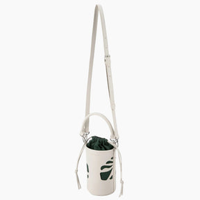 White crossbody bag with a plant inside on a white background
