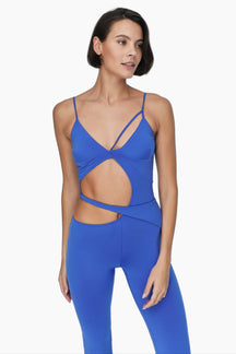 Woman wearing a blue jumpsuit Featuring asymmetric cut out details and chic straps.