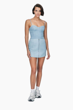 Woman wearing a nesta blue denim, this top feature sultry bustier neckline and chic corset shape, featuring a matching skirt 