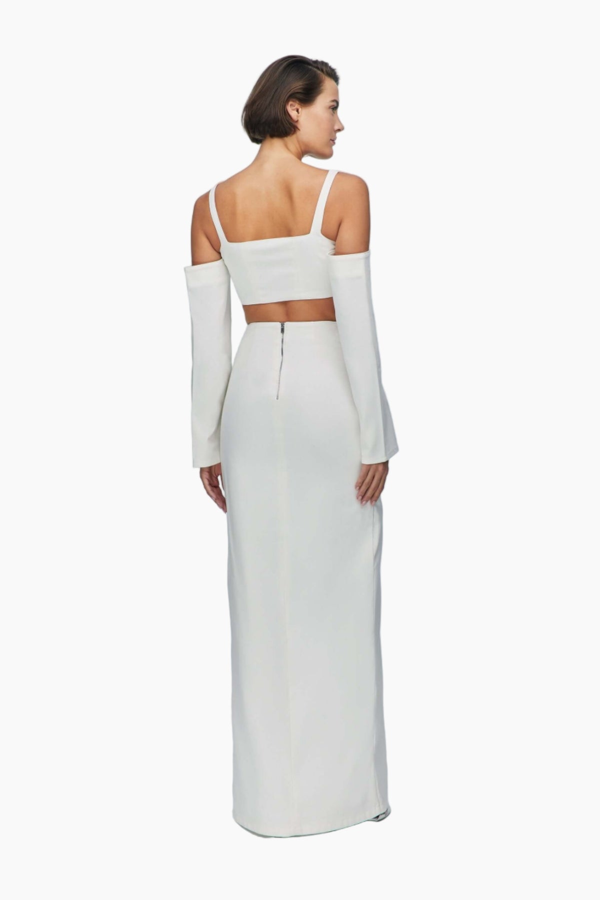 Woman wearing a white denim top with long sleeves and a high slit skirt