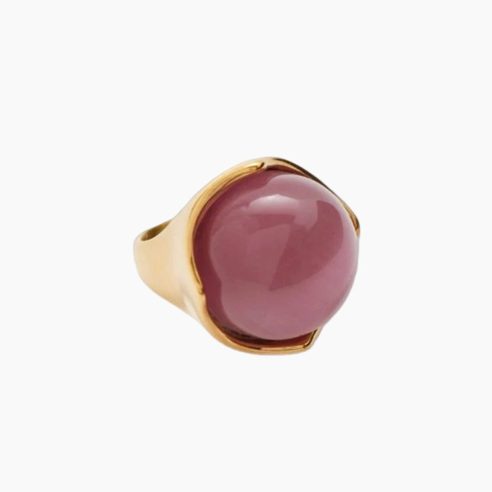 Gold ring with a pink stone on a white background