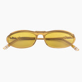 Gold-framed sunglasses with yellow lenses on a white background