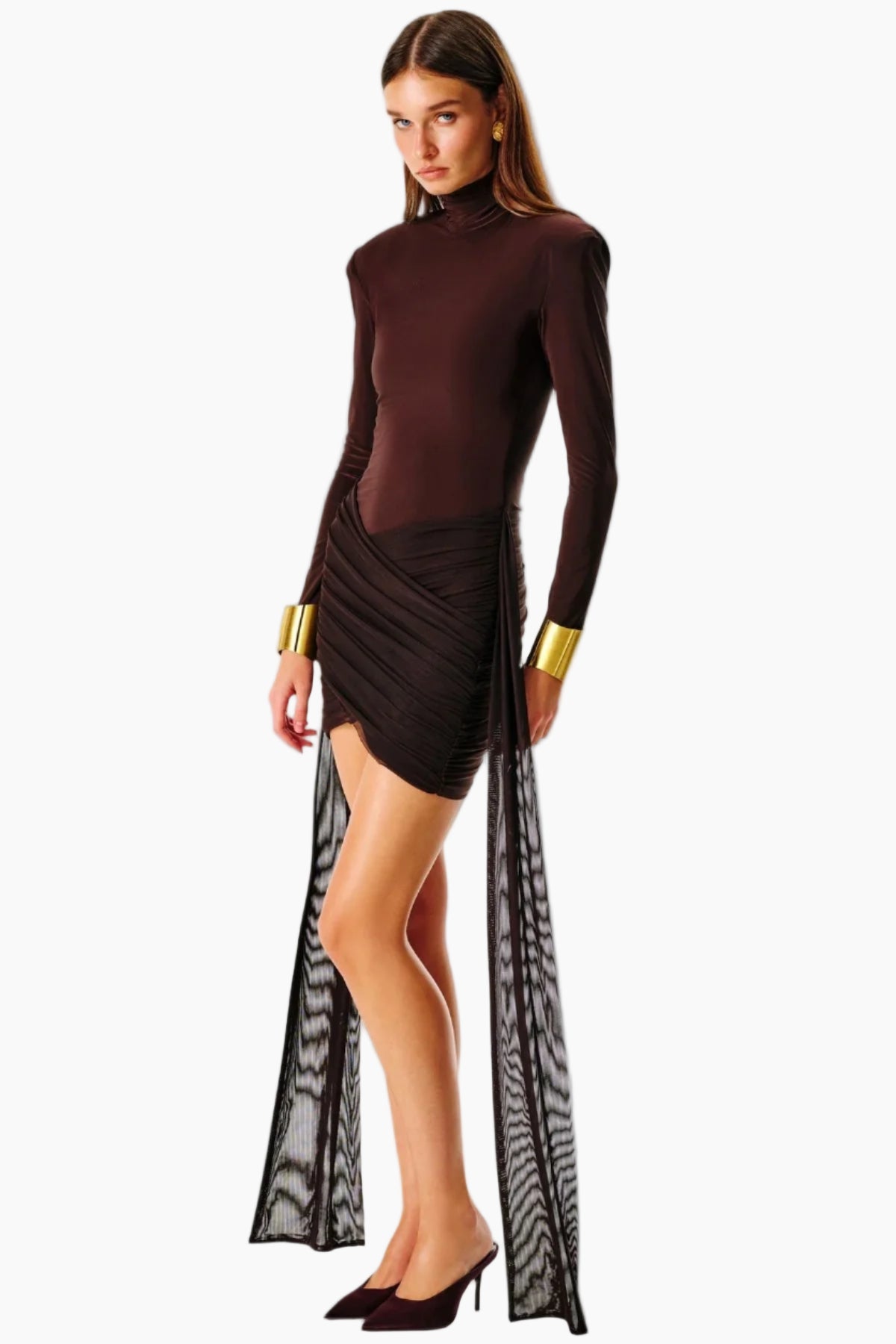 Woman wearing a dark brown long-sleeve top and skirt with gold accents 