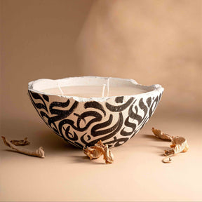Ceramic bowl with black abstract patterns on a beige background