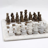 Marble chess set with white and brown pieces on a white background