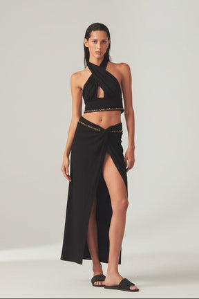 Woman in a black outfit top and a wrap skirt