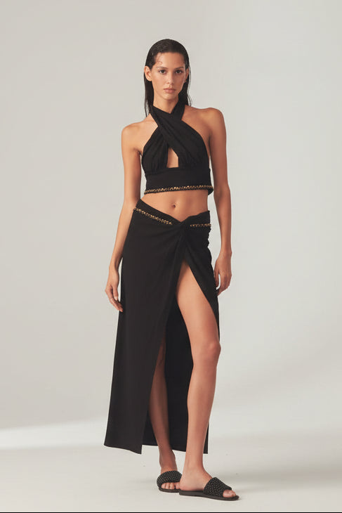 Woman in a black outfit top and a wrap skirt