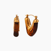 Gold hoop earrings with brown gemstones on a white background