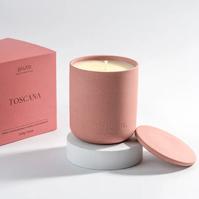 Pink candle with matching lid and 'pluto' branding 