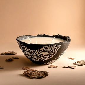 Ceramic bowl with white candle inside on a beige background