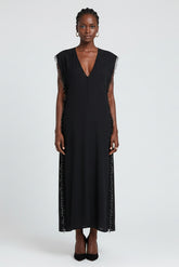 Black sleeveless dress with fringe details on a white background