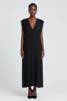 Black sleeveless dress with fringe details on a white background