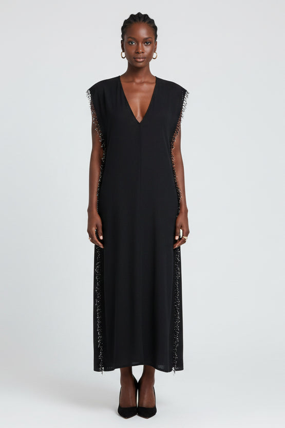 Black sleeveless dress with fringe details on a white background