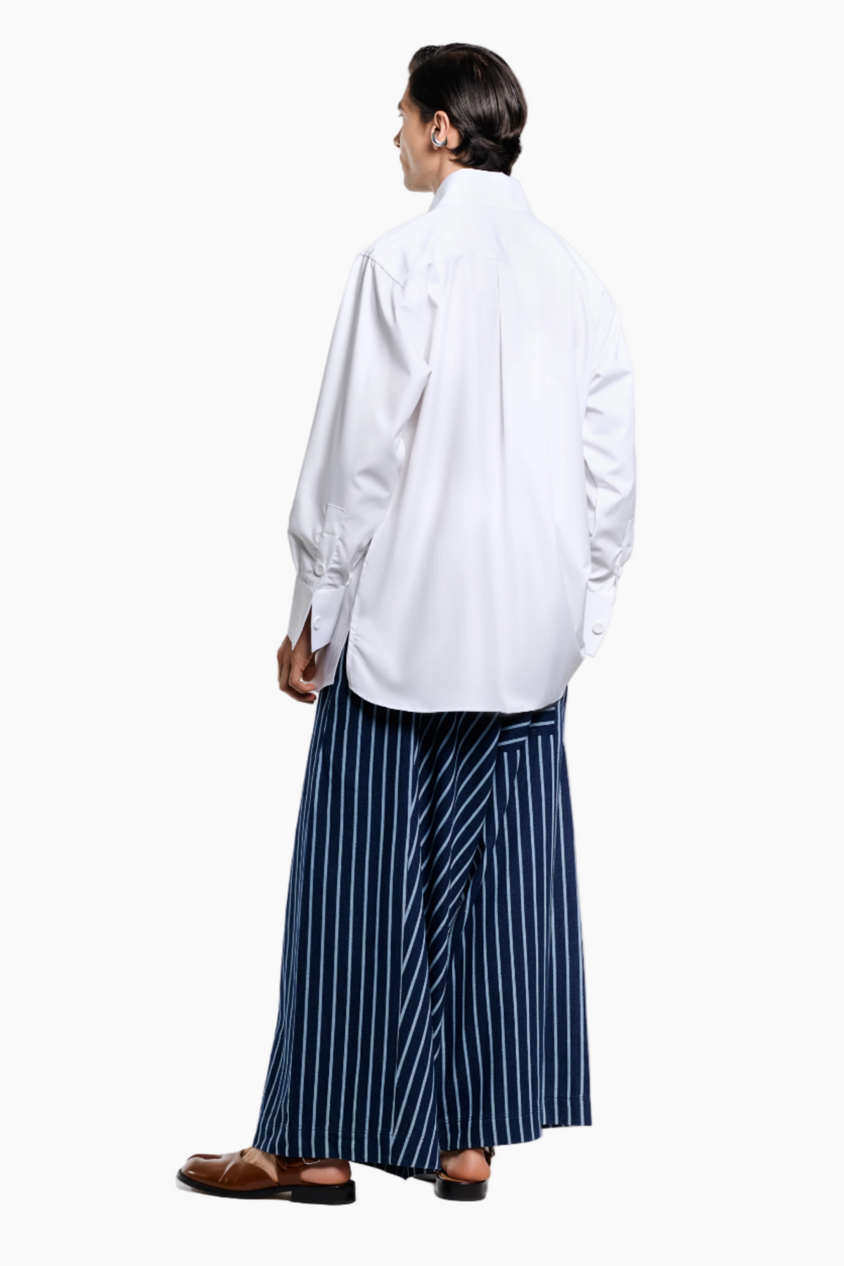 Person wearing a white shirt and blue striped skirt on a white background