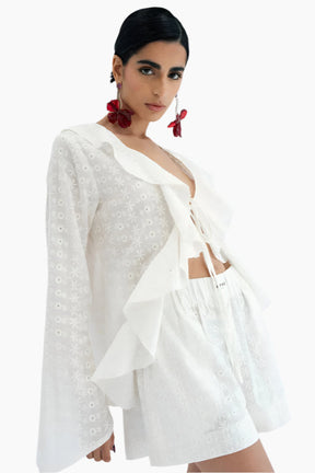 model wearing a white lace shirt  with a matching white shorts