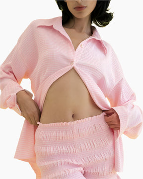 women wearing half buttoned long sleeve pink shirt and a matching shorts 