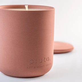 Terracotta-colored candle with 'pluto. Art & Home Decor' branding 