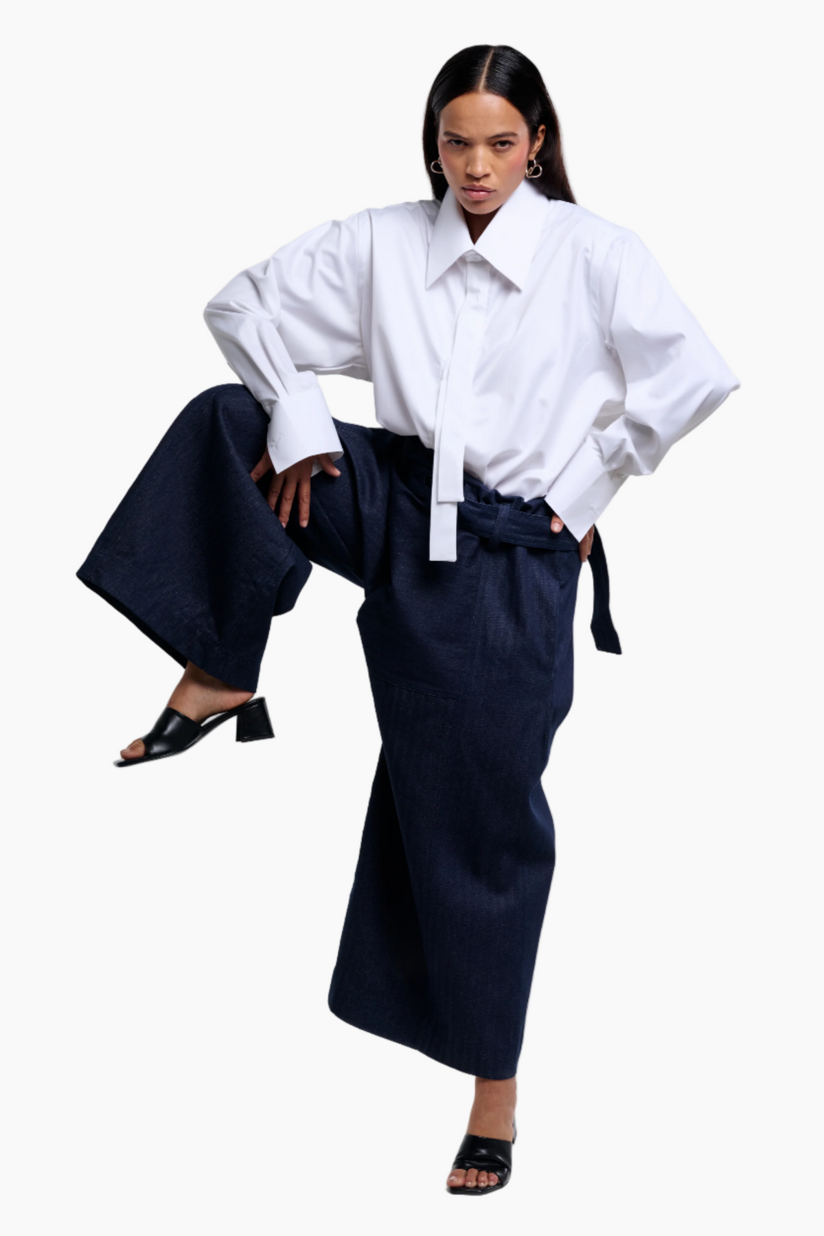 Woman wearing a white shirt and navy pants on a white background