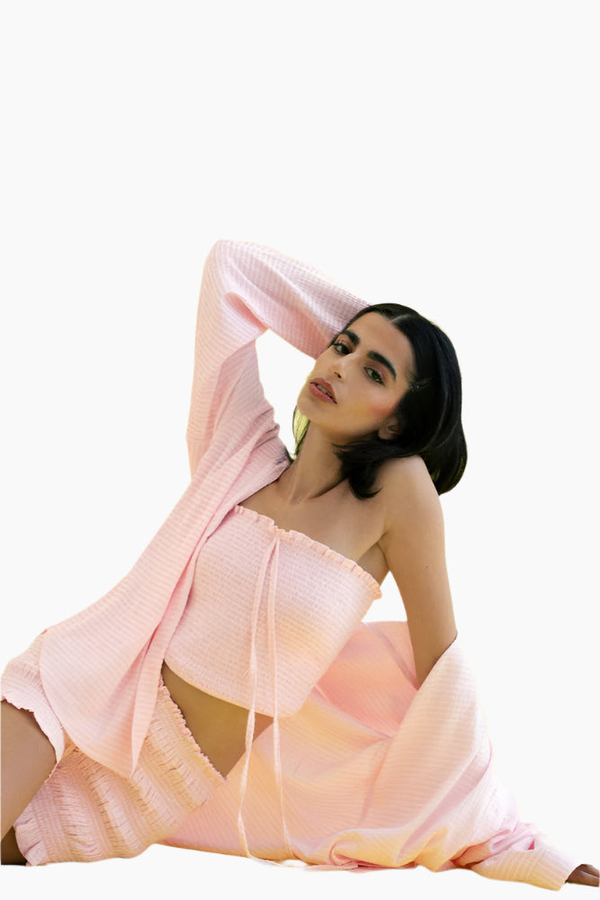 Woman wearing a pink outfit, crop top , long sleeve matching shirt 