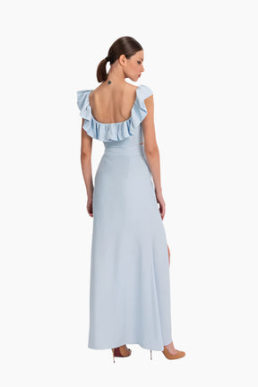 linen set featuring a charming top and skirt ensemble. The top boasts delicate ruffles adorning the neckline. The skirt features a flattering high waist design with a slit in the front.