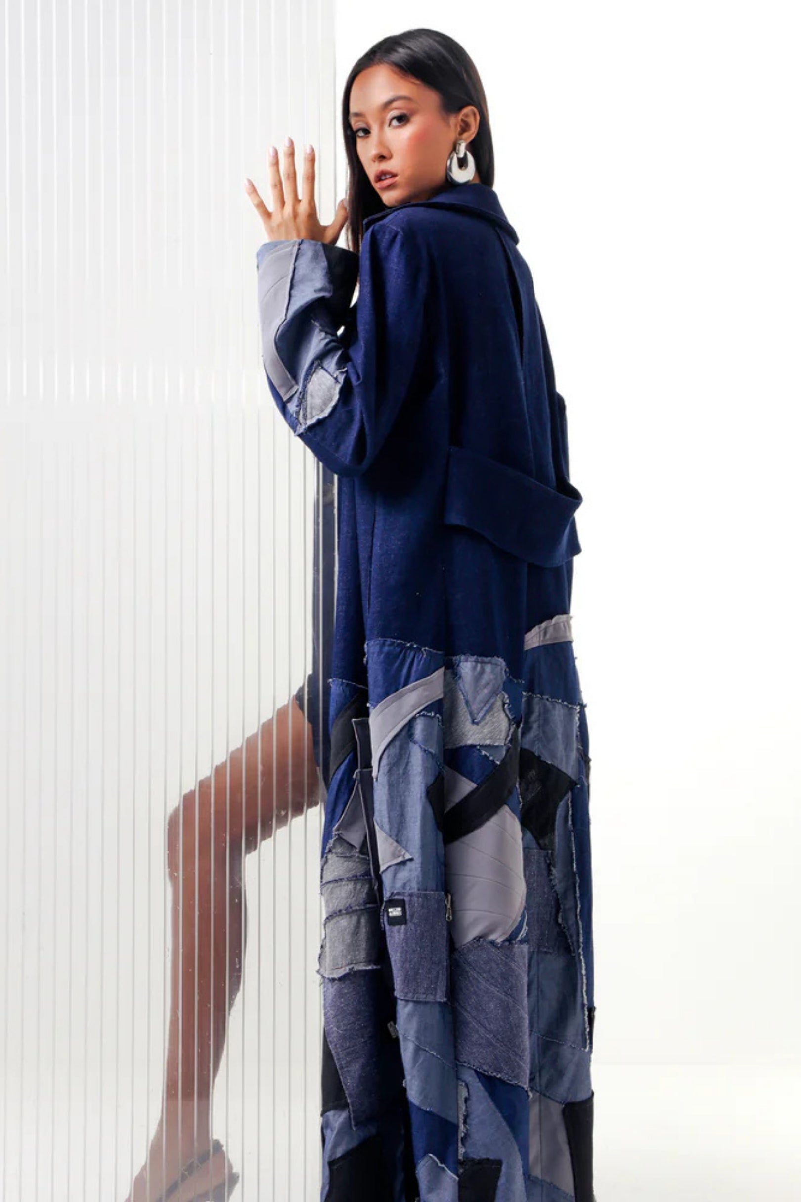 Woman wearing a blue and gray outfit with a patterned skirt