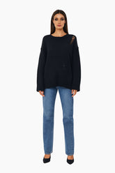 Woman wearing a black sweater and blue jeans 