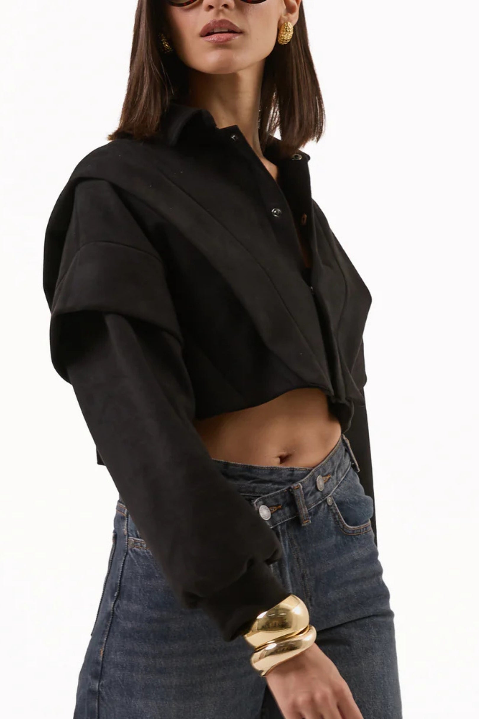 Person wearing a black cropped hoodie and blue jeans 