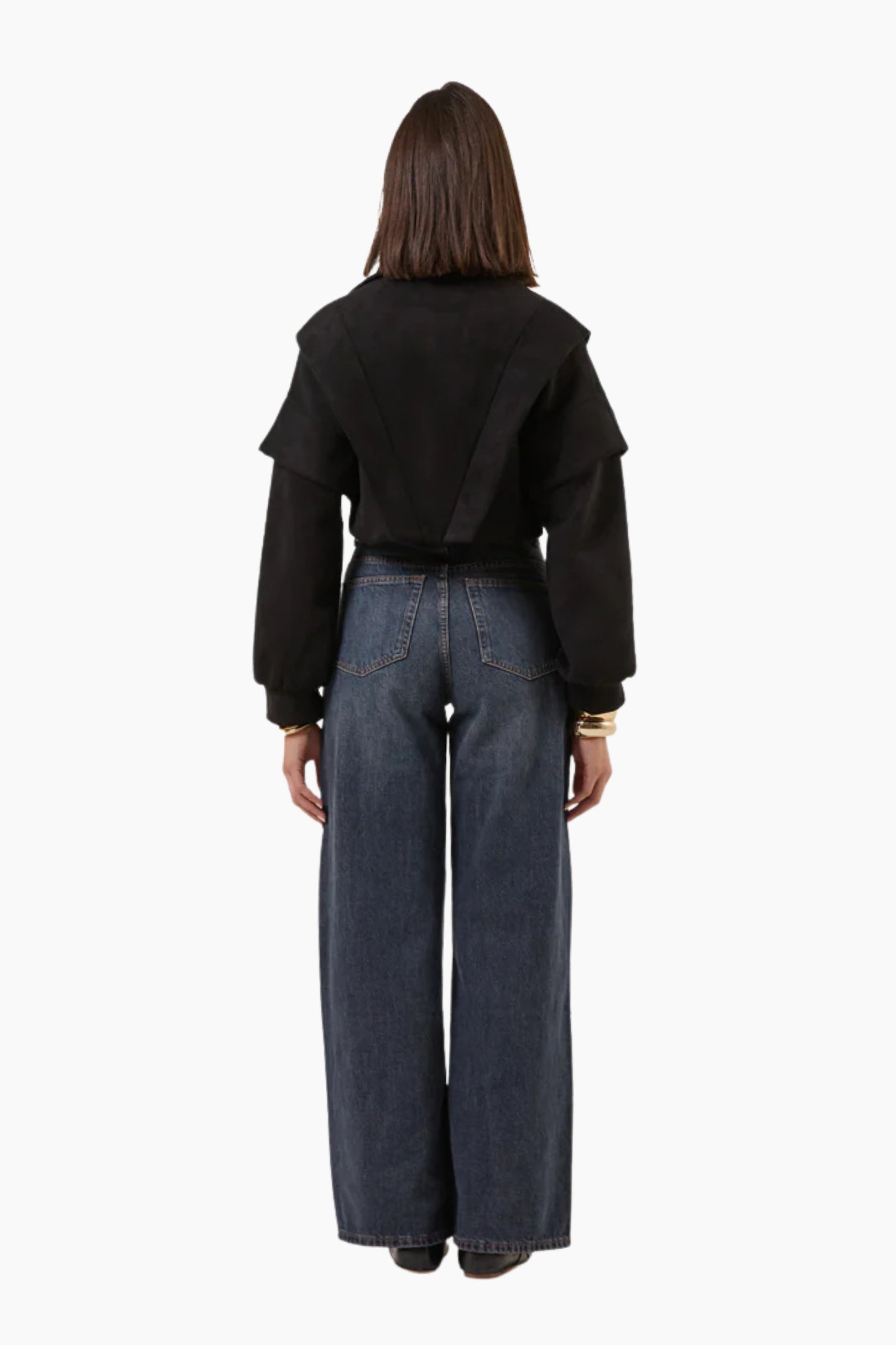 Person wearing a black jacket and blue jeans 