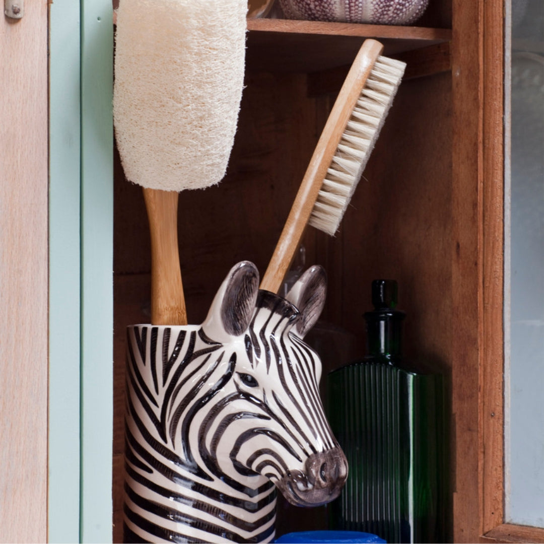 Zebra-shaped brush holder with a scrubbing brush and other items