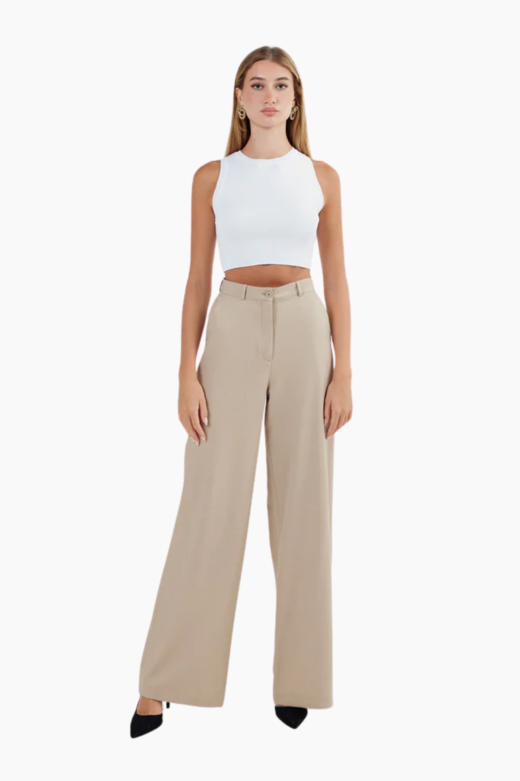 Woman wearing a white sleeveless top and beige high-waisted pants