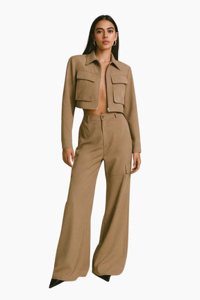 Woman wearing a beige cropped jacket and wide-leg pants 