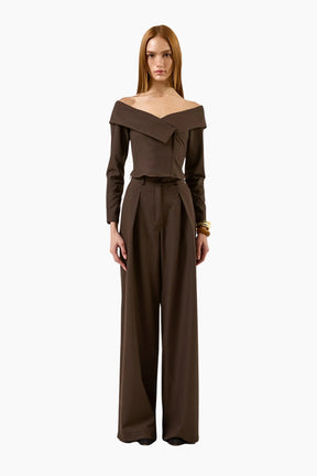 model wearing an Off-shoulder double-breasted long-sleeves top with brown pants.