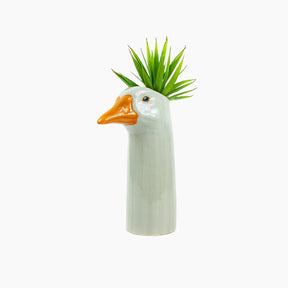 Ceramic vase shaped like a duck with a plant 