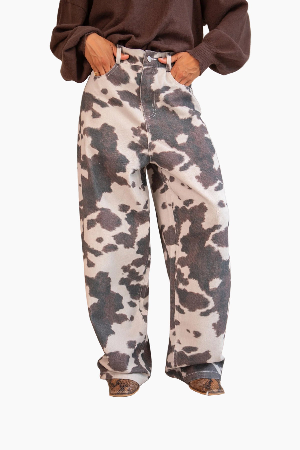 Person wearing cow print pants in a room 